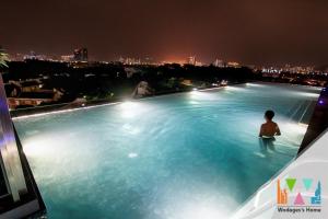 a man standing in a swimming pool at night at Expressionz KLCC by Wodages, 300mbps Wifi in Kuala Lumpur