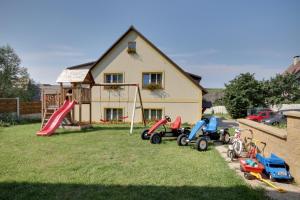 un patio con un montón de juguetes delante de una casa en Guest House Pod Hájkem, en Horní Branná
