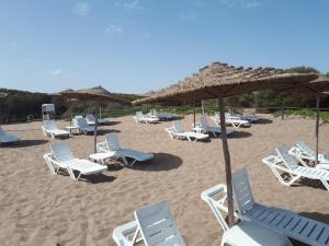 a group of chairs and umbrellas on a beach at Résidence Dreamland in Sidi Rahal