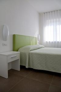 a bedroom with two beds and a table and a window at Casa Rosa dei Venti in Nago-Torbole