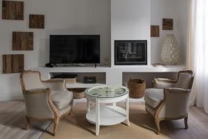 ein Wohnzimmer mit einem Tisch und Stühlen sowie einem TV in der Unterkunft La maison de Colette, Traditionnelle Maison d'Armateur de 3 chambres et 3 salles de bains in Honfleur