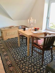 a dining room with a wooden table and chairs at Ferienwohnung Seefrieden in Westensee