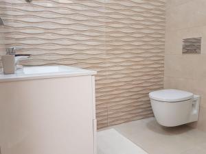 a bathroom with a white toilet and a sink at Vila Alikaj in Sarandë +22 photos