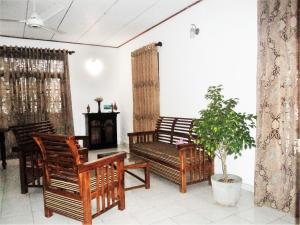 a living room with wooden chairs and a fireplace at Unawatuna House in Unawatuna