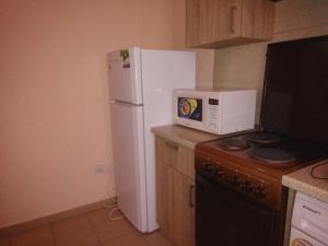 a kitchen with a white refrigerator and a microwave at Лиманский in Korenovsk