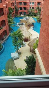 a view of a resort with blue water and straw umbrellas at seven seas by wandee in Jomtien Beach