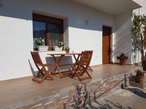 a wooden table and chairs on a patio at Vila Alikaj in Sarandë