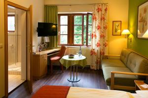 a hotel room with a couch and a table in a room at Hotel Reichsküchenmeister in Rothenburg ob der Tauber