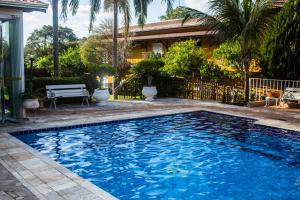 a swimming pool in front of a house at Pousada Shangrila in Ribeirão Preto