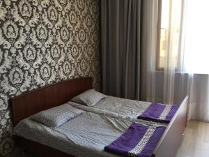 a bedroom with a bed with a purple blanket on it at Guest house Romanadze in Kobuleti