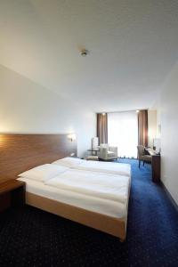 ヘール・グレンツハウゼンにあるHotel Siliciumの大きなベッドとデスクが備わるホテルルームです。