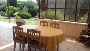 uma mesa com cadeiras e uma toalha de mesa com bolinhas amarelas em Gite l'Annexe em Villelaure