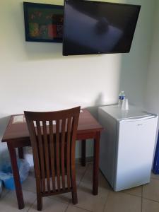 a small table with a chair and a small refrigerator at Hotel La Marmotte** in Matoury