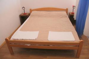 een bed in een kamer met 2 nachtkastjes en 2 tafels bij Guesthouse Donko 1 & 2 in Senj
