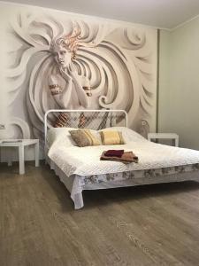 a bedroom with a bed with a painting on the wall at Apartment on Pastukhova 31 in Pyatigorsk