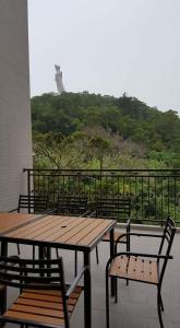 a picnic table and chairs on a balcony with a view at GOD’S Queen Esther in Nangan