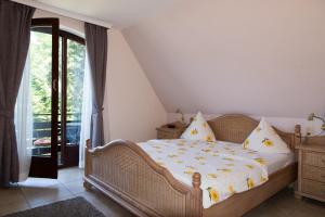 Schlafzimmer mit einem Bett mit gelber und weißer Bettwäsche in der Unterkunft Wennhof in Scharbeutz