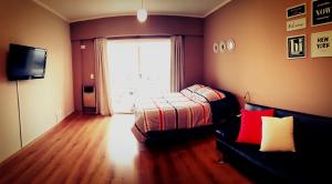 1 dormitorio con cama, sofá y ventana en Modern Apartment Rivas - Swimming Pool en Buenos Aires