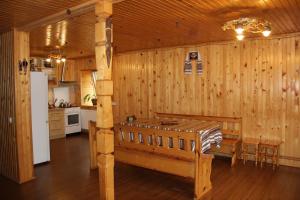 a kitchen with wooden walls and a table and a refrigerator at Cottage Milena in Mykulychyn