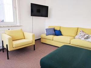 a living room with two chairs and a couch and a tv at Ferienwohnung Hochgefühl in Hohegeiß