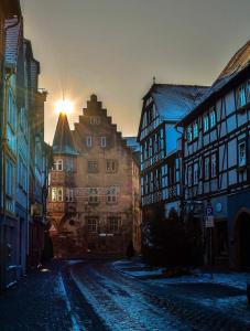 a city street with buildings and the sun in the distance at Ferienwohnung Lilly in Büdingen
