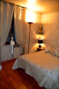 a bedroom with a bed and a lamp and a window at Villa Cyriel in Contes