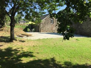 a stone building with a picnic table and a tree at Callac gîte P 8 in Plumelec