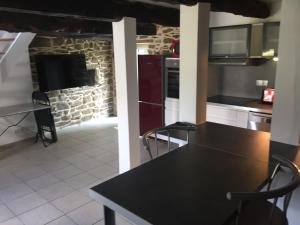 uma cozinha com uma mesa preta e cadeiras em Callac gîte P 8 em Plumelec