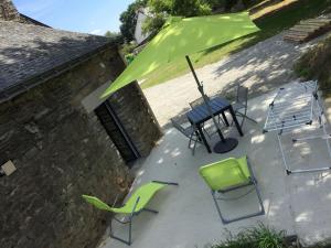a patio with a table and chairs and an umbrella at Callac gîte P 8 in Plumelec