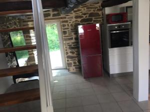 uma cozinha com um frigorífico vermelho num quarto em Callac gîte P 8 em Plumelec