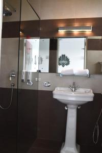 a bathroom with a sink and a glass shower at Hotel J Ambalangoda in Ambalangoda
