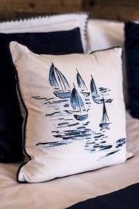 a pillow on a bed with boats in the water at The Lighthouse Penthouse, Studio and Holiday Home in St Ives