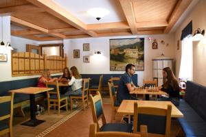 een groep mensen die aan tafel zitten in een restaurant bij Hotel Zanella in Peio Fonti