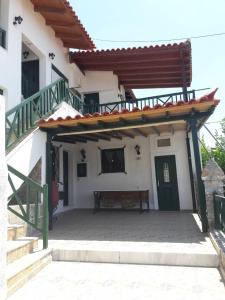 een veranda van een huis met een bank en een trap bij Elgina Apartments 1 Rethymno in Plakias
