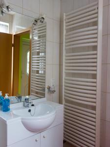 a white bathroom with a sink and a mirror at Ferienwohnung Holunderweg in Bad Doberan