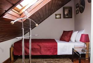 a bedroom with a bed with a red and white blanket at Miha Apartman in Subotica
