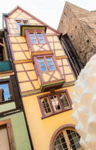 un edificio giallo con finestre sul lato di MY SWEET HOMES - STUDIO "LE CAVEAU" a Colmar