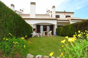 a house with a yard with flowers in front of it at La Platera Villas in L'Estartit