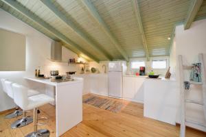 a kitchen with white appliances and a wooden ceiling at Mavres Luxury Loft in Ágios Matthaíos