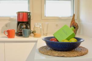 a bowl of fruit on a counter with a book on it at Mavres Luxury Loft in Ágios Matthaíos