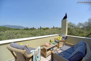 un patio con sedie e un tavolo sul balcone. di Mavres Luxury Loft ad Ágios Matthaíos
