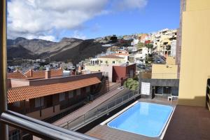 Apartamento Nek في سان سيباستيان دي لا غوميرا: اطلالة من البلكونة على مبنى مع مسبح