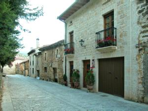 an alley in an old stone building with flower boxes at Casa Rural Las Condesas in Santo Domingo de Silos