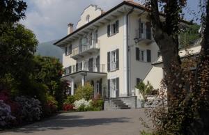 a large white building with a staircase in front of it at B&B Le Camelie in Domodossola