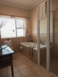 a bathroom with a bath tub and a shower at At 29 Columba in Groot Brak Rivier +62 photos