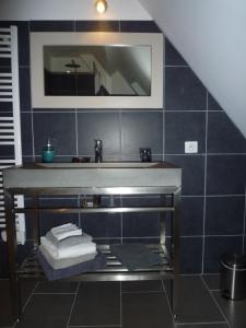 La salle de bains est pourvue d'un lavabo et d'un miroir. dans l'établissement Chambres d'Hôtes Les Potiers, à Sens-Beaujeu