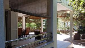 eine Veranda eines Hauses mit Stühlen und einem Tisch in der Unterkunft Green Paradise Apartment Novalja in Novalja