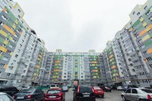 スームィにあるVIP Apartments Faraon on Kharkovskaya 1 floorの高層ビルの前に車を駐車した駐車場