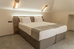 a bedroom with a large bed with white sheets and pillows at Hugo Hotel in Varna City