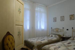 a bedroom with two beds and a window at B&B Le Camelie in Domodossola